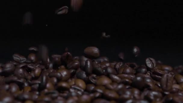 Kavrulmuş Kahve Çekirdeklerinin Siyah Arkaplanlı Kahve Çekirdeklerinin Üzerine Düşüşünü Yakından — Stok video