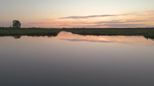 夕阳西下 空中射过一片绿地 上面有一个湖 — 图库视频影像