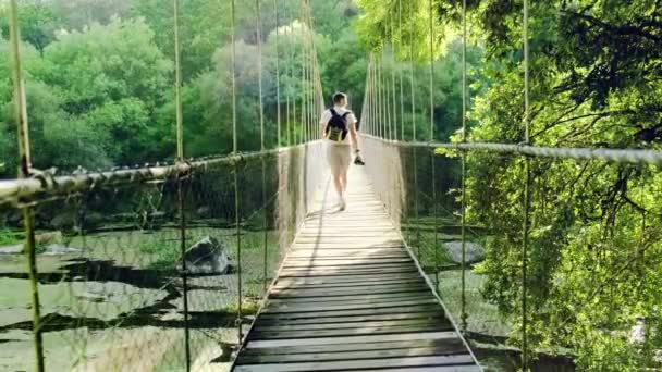 Fotógrafo Aventurero Alejarse Cámara Cruzando Puente Cuerda Supension Rodeado Exuberante — Vídeo de stock