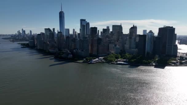 在阳光灿烂 蓝天的日子里 可以看到曼哈顿下城和纽约港的全景 镜头朝北 朝向曼哈顿下城的卡车正好穿过平静的河流 阳光照在水面上 — 图库视频影像