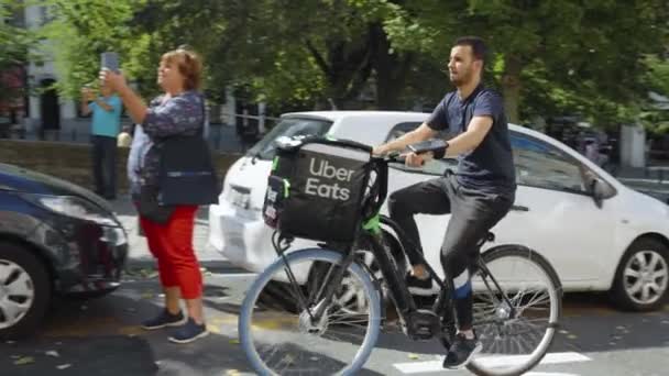 Uber Eats Delivery Bike Rider Passing Fanfare Music Parade Downtown — Vídeo de stock