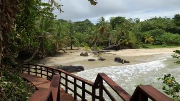 背景には手すりと楽園のビーチがある木製の歩道のパンニングショット — ストック動画