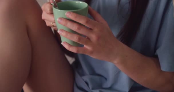 茶のカップを持つ少女の手は 椅子ぶら下げ上に足を踏んで座っている ジンバル近くに — ストック動画