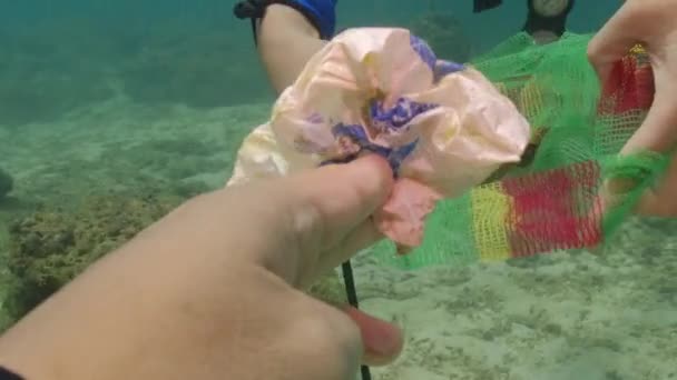 スキューバダイバーは海の下でごみプラスチックごみを拾う 海洋汚染 水中で — ストック動画