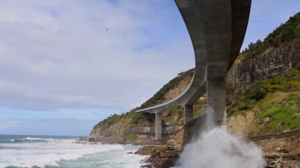 Ondas Atingindo Rochas Sob Uma Grande Ponte Sinuosa Sea Cliff — Vídeo de Stock