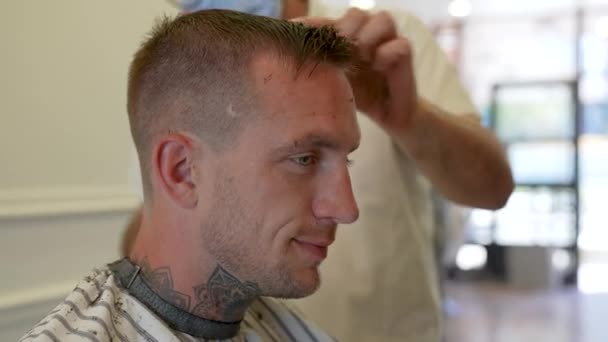 若い白人男性が市内の美容院で散髪をしていて — ストック動画
