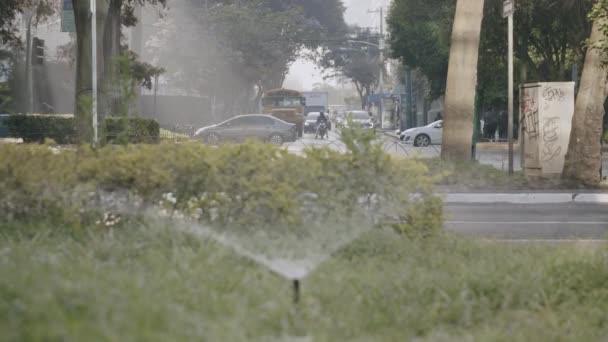 汽车在街上行驶的慢镜头 前景中的洒水装置不集中 — 图库视频影像