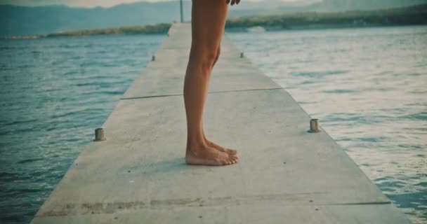 Kadının Bacakları Denizin Üzerinde Ayakkabısız Bir Iskelede Duruyor Etrafında Dönüyor — Stok video