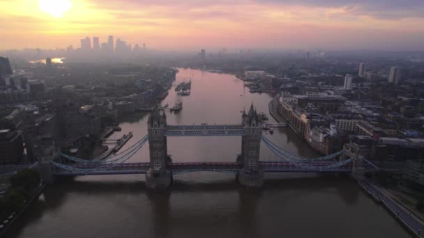 象徴的なタワーブリッジ黄色のオレンジの夕日の空とロンドンのテムズ川にまたがる 橋の間を空飛ぶドリーフォワード — ストック動画