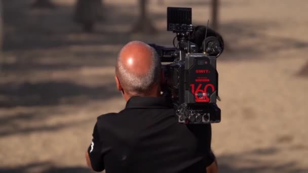 Senior Camera Operator Riprese Con Fotocamera Pro Sulla Spalla Retrovisore — Video Stock