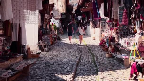 町の古い部分で石畳の道を歩く若いカップル — ストック動画