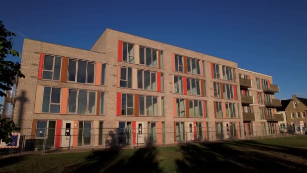 オランダのエンジニアリング不動産投資都市開発プロジェクトの空中上昇空の青の空とは対照的なカラフルな建物と日の出のUbuntuの — ストック動画