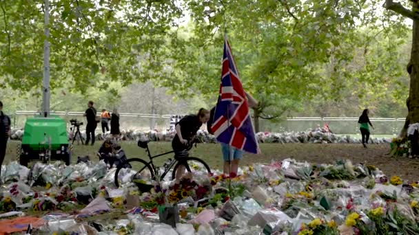 Stor Union Jack Flagg Flaggning Vinden Omgiven Blommiga Hyllningar För — Stockvideo