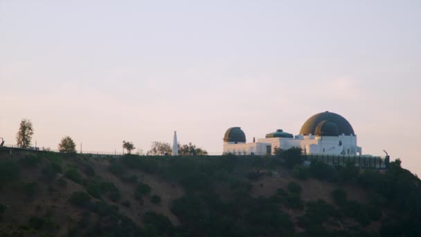 1935年に設立されたグリフィス天文台は 南カリフォルニアの宇宙への玄関口である ロサンゼルスのグリフィス公園に位置し 夏の日の夜明けに見られます — ストック動画