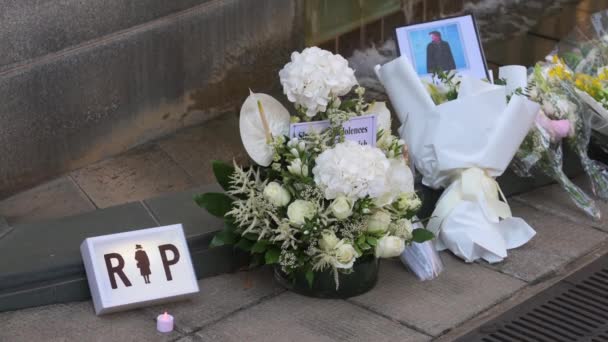 Een Bord Met Het Woord Rip Zien Naast Bloemen Boeketten — Stockvideo