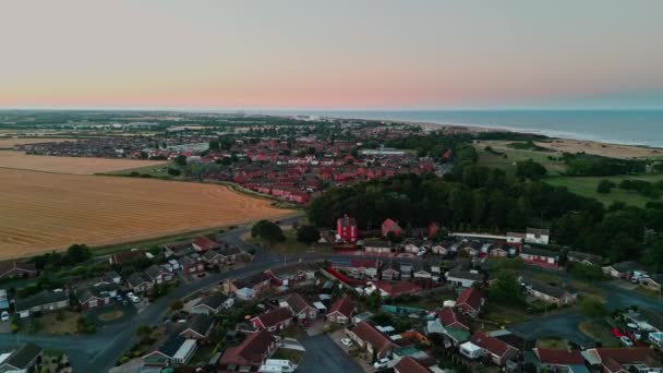 Skegnessの海岸沿いの町やゴルフコースの日没の空撮距離でIngoldmelsの町を示しています フェアグラウンドライドと — ストック動画