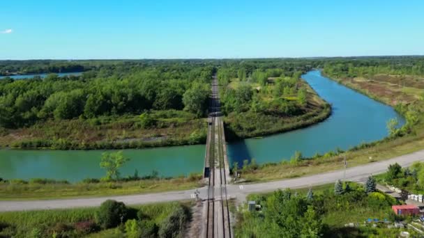 カナダ国内の道路や川を横断する鉄道線路の前方空中 — ストック動画