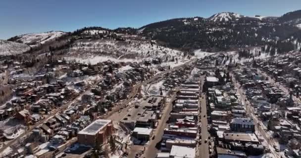 パークシティユタ航空V10ドローンがダウンタウン周辺を飛び回り 山脈に囲まれた丘の中腹にある住宅や別荘を撮影 Mavic Cineで撮影 2022年2月 — ストック動画