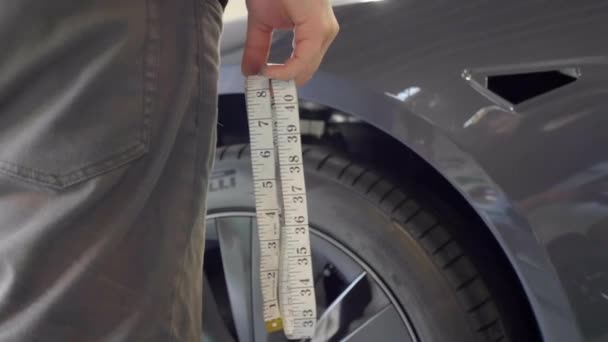 修车工场工人在汽车附近保持测量带 — 图库视频影像