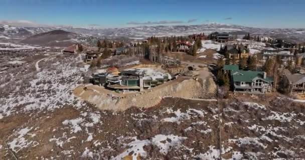 パークシティユタ航空V64便丘の上の豪華な休暇の家の周りを飛ぶ雪と丘陵地帯の街並みに覆われた周囲の山脈をキャプチャ マヴィックで撮影3 Cine 2022年2月 — ストック動画