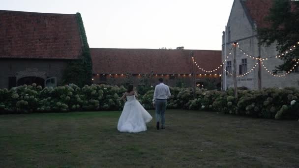 結婚式のカップルは結婚式のパーティーに向かって歩く — ストック動画