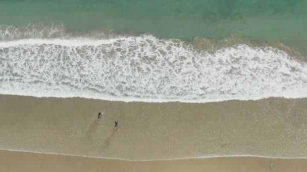 两名冲浪者前往英国康沃尔纽奎的海岛海滩冲浪的俯视图 — 图库视频影像