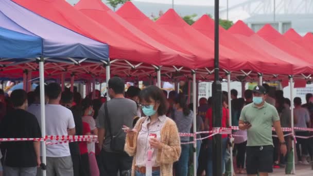 市民排队接受社区测试中心卡车提供的验尸报告 Covid 以应付禽流感病毒的蔓延及在香港金融区附近出现的流感大流行 — 图库视频影像