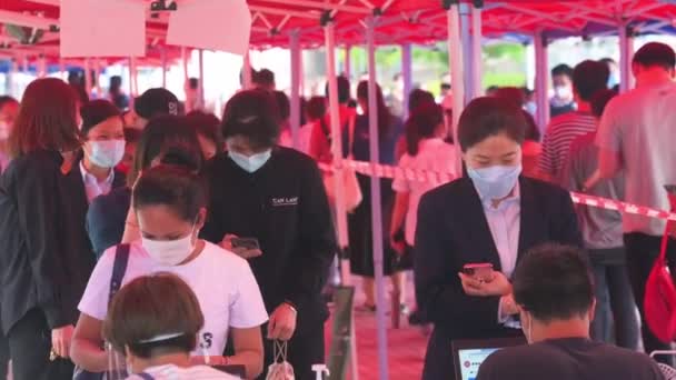 人々は列に並び 香港のウイルスとパンデミック波の普及に取り組むためにコミュニティテストセンターのトラックからコロナウイルス Covid のPcr検査を受けるために登録します — ストック動画