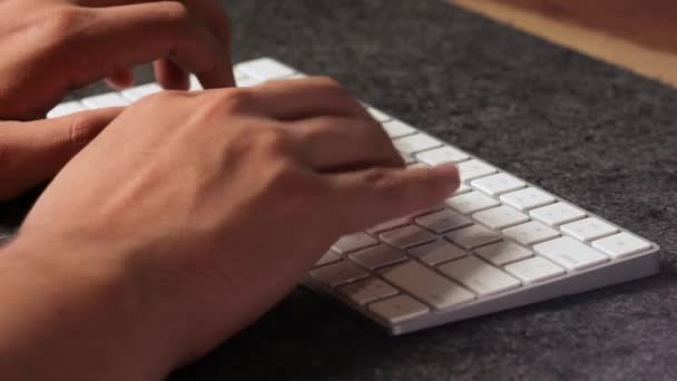 男性拉蒂诺手用他所有的手指在白色无线键盘上快速打字 — 图库视频影像