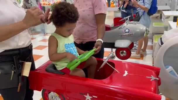 Υπέροχο Δίχρονο Παιδί Στο Κομμωτήριο Κάθεται Ένα Κόκκινο Αυτοκινητάκι Συγκεντρωμένο — Αρχείο Βίντεο
