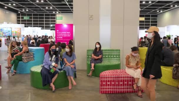 在一个向公众开放的当代艺术博览会期间 人们看到艺术购买者和参观者坐在一个休息区的彩色长椅上 — 图库视频影像
