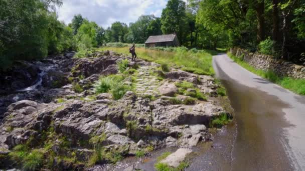 Młody Chłopiec Przemierzający Skały Lake District Kamerą Statywem — Wideo stockowe