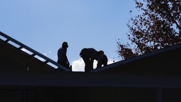 Silueta Retroiluminada Los Trabajadores Que Trabajan Techo Una Casa Construcción — Vídeos de Stock