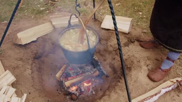 Mann Mit Mittelalterlichem Kostüm Kocht Eintopf Topf Lagerfeuer Zeitlupe — Stockvideo