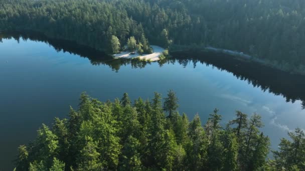 日の出の輝きが水から跳ね上がる穏やかな湖で公共ボートの打ち上げの広いドローンショット — ストック動画