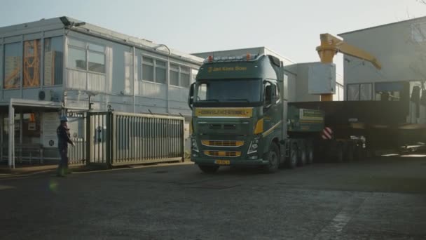 Spotter Dirigiert Riesigen Lkw Auf Der Werft Mit Handsignalen Breit — Stockvideo