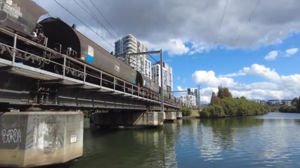 Duży Pociąg Towarowy Porusza Się Powoli Przez Most Nad Wodą — Wideo stockowe