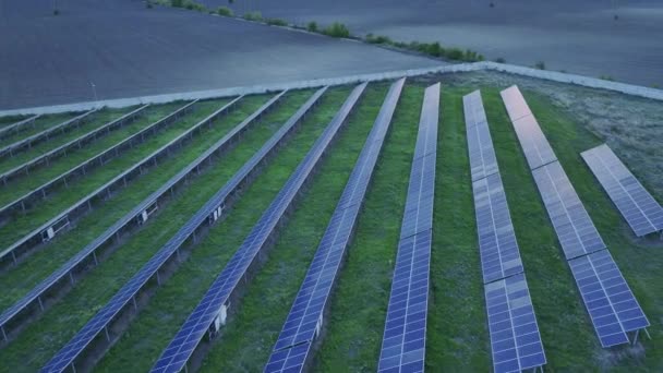 カラフルな空で日没の間に太陽電池パネルのショットを明らかにするドローン軌道傾斜アップ — ストック動画