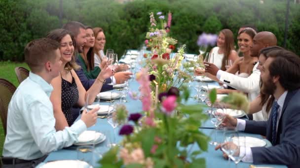 Esküvői Vendégek Változatos Csoportja Nevet Éljenzik Menyasszonyt Vőlegényt Vacsorán — Stock videók