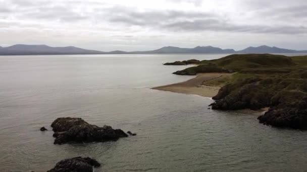 Ynys Llanddwyn岛威尔士海岸海滩 爱尔兰海对面的雪多尼亚山脉 — 图库视频影像