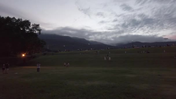 日落时分 许多人在绿草场里享受户外活动 — 图库视频影像