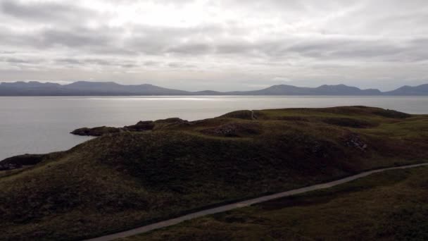 从空中俯瞰Ynys Llanddwyn岛的英格利塞岛海岸小径与雪多尼亚山脉穿过爱尔兰海面 — 图库视频影像