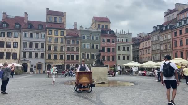 ポーランド ワルシャワの城広場で過去のストリートパフォーマーを歩く観光客曇りの日 — ストック動画