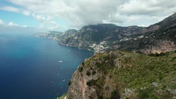 広大な崖の顔 緑の山々 地中海の海とヨットで イタリアのAmalfi海岸でPositanoの航空追跡ショット 4Kで撮影された美しいイタリアのビーチや海岸線のドローン — ストック動画