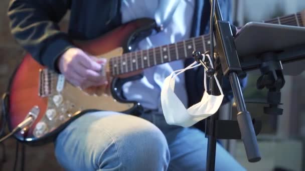 Artista Tocando Guitarra Durante Pandemia Covid Mascarilla Colgando Sobre Soporte — Vídeos de Stock