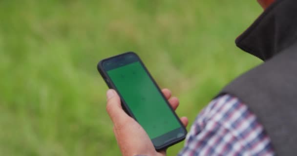 牛仔带着绿色屏风带着智能手机 在农场追踪臭虫 慢动作 — 图库视频影像