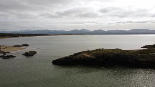从空中俯瞰Ynys Llanddwyn岛 安吉丽岛沿海小径与雪多尼亚山脉穿过爱尔兰海 — 图库视频影像