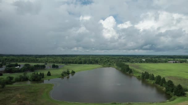 화면에는 수많은 나무와 과드넓은 하늘로 둘러싸인 도로에 가까운 호수가 보인다 — 비디오