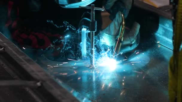 在慢动作的焊机上发出明亮的蓝色火花 焊机手焊缝金属部分到机架上固定位置的慢动作 — 图库视频影像