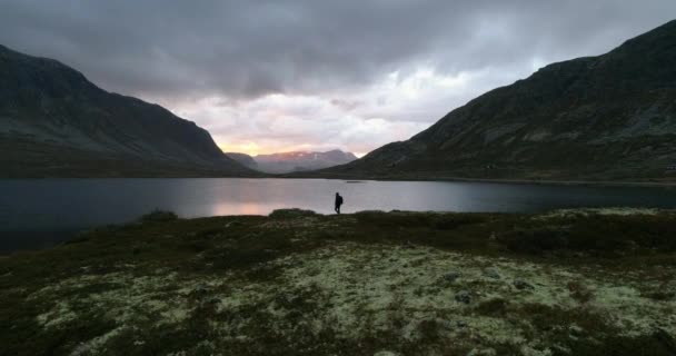 Vandrare Står Vid Mörk Dal Sjö Med Gyllene Majestätisk Solnedgång — Stockvideo